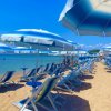 Una spiaggia con lettini e ombrelloni blu.