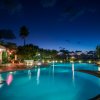 Piscina illuminata di sera con cielo stellato.