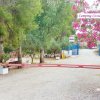 Ingresso di un campeggio con sbarra e fiori rosa.