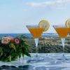 Due cocktail con fette di limone su un tavolo, vista mare.