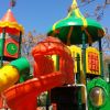 Colorato parco giochi all'aperto con scivoli e torrette.