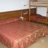 Camera da letto con letto matrimoniale e un letto a castello, copriletti rossi.